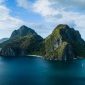 Pemandangan udara gugusan pulau karang menakjubkan yang dikelilingi perairan jernih bergradasi biru di kawasan wisata bahari unggulan Indonesia.
