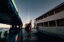 Sebuah kapal phinisi tradisional melintasi perairan jernih di sekitar gugusan pulau Labuan Bajo, Nusa Tenggara Timur. Wisata berlayar menjadi salah satu daya tarik utama pelancong domestik untuk menikmati keindahan lanskap alam Indonesia dari atas laut.