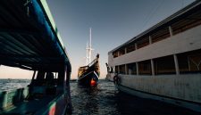 Sebuah kapal phinisi tradisional melintasi perairan jernih di sekitar gugusan pulau Labuan Bajo, Nusa Tenggara Timur. Wisata berlayar menjadi salah satu daya tarik utama pelancong domestik untuk menikmati keindahan lanskap alam Indonesia dari atas laut.