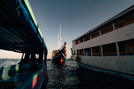 Sebuah kapal phinisi tradisional melintasi perairan jernih di sekitar gugusan pulau Labuan Bajo, Nusa Tenggara Timur. Wisata berlayar menjadi salah satu daya tarik utama pelancong domestik untuk menikmati keindahan lanskap alam Indonesia dari atas laut.